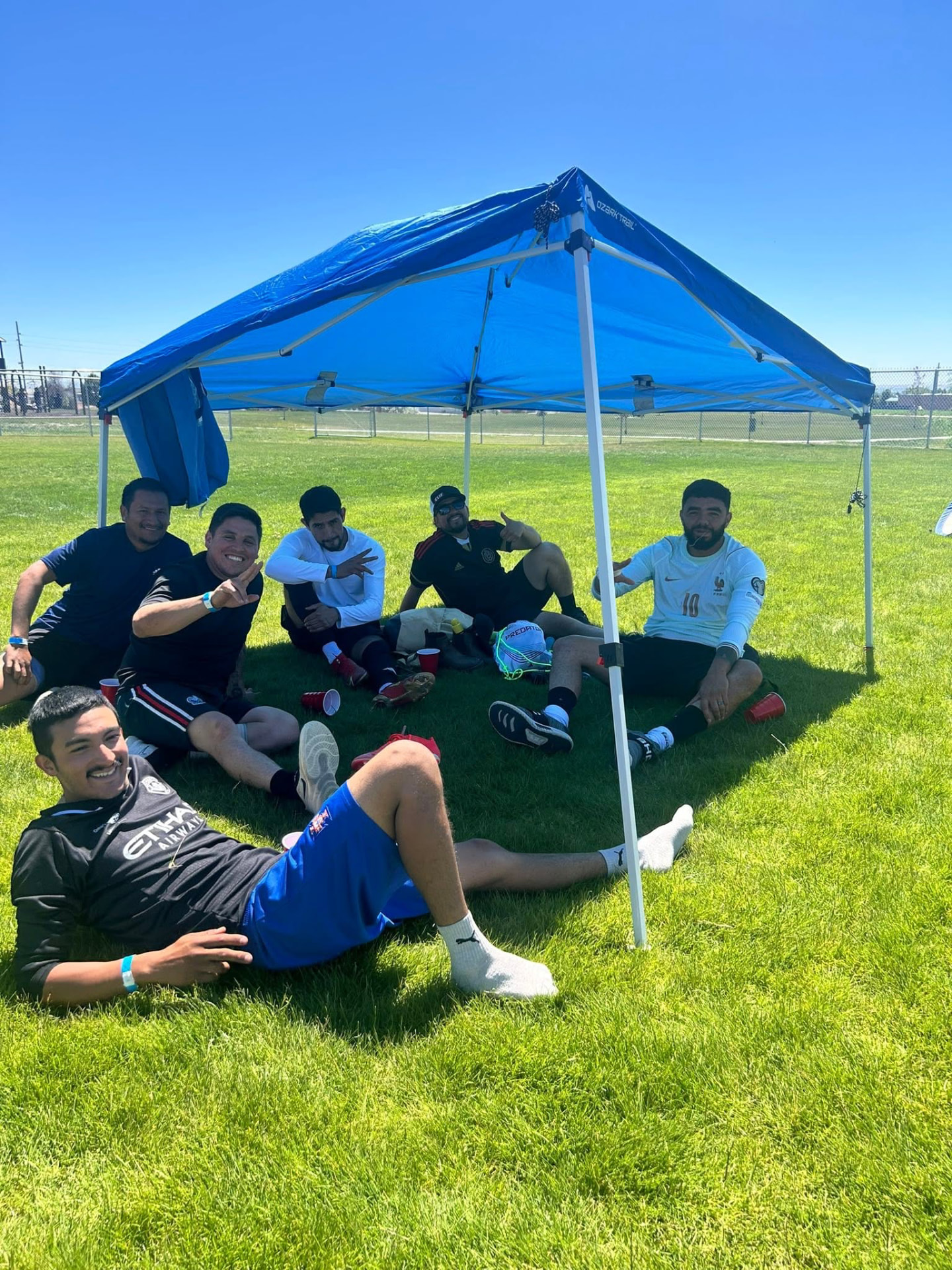 Players relaxing together under a canopy at Copa Tricolor